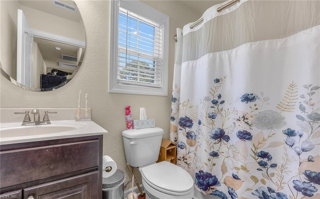 full bath featuring visible vents, vanity, a shower with shower curtain, and toilet