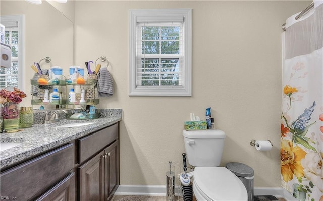 full bath featuring baseboards, toilet, vanity, and curtained shower