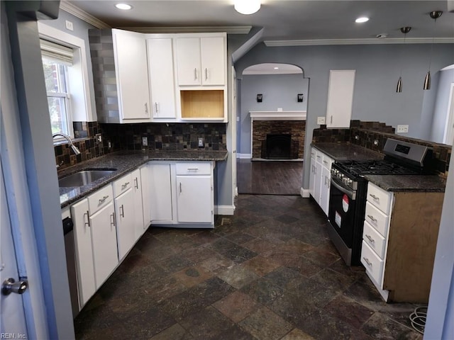 kitchen with white cabinetry, stainless steel gas range oven, sink, and crown molding