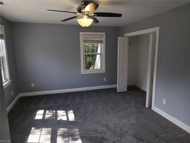 unfurnished bedroom featuring dark colored carpet, ceiling fan, and a closet