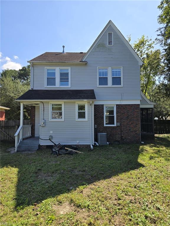 back of house featuring a lawn and central air condition unit