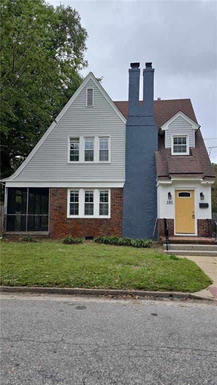 view of front facade with a sunroom and a front yard