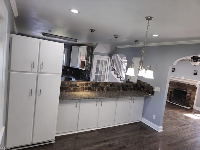 kitchen with dark hardwood / wood-style floors, pendant lighting, white cabinetry, decorative backsplash, and dark stone counters