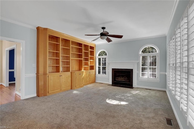 unfurnished living room with ceiling fan, carpet flooring, and ornamental molding