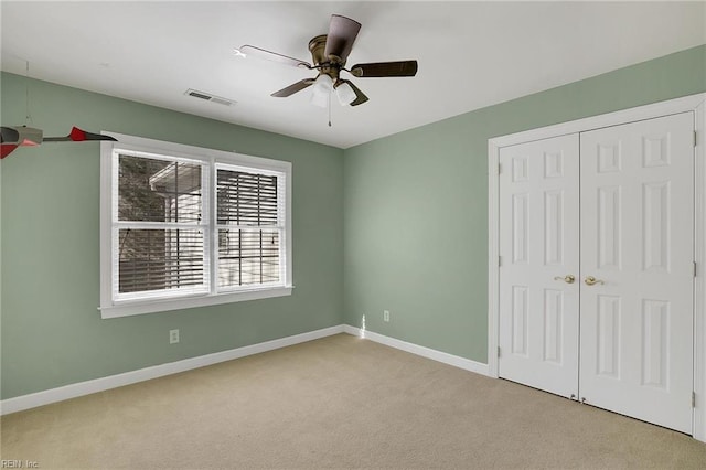 unfurnished bedroom featuring light carpet, ceiling fan, and a closet