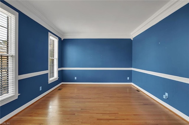 spare room featuring wood-type flooring and crown molding