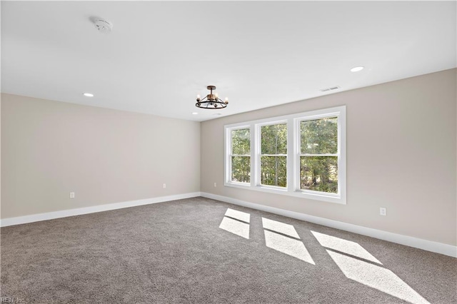 carpeted empty room featuring baseboards, visible vents, recessed lighting, and a chandelier