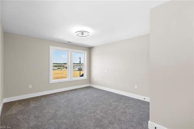 empty room featuring carpet and baseboards