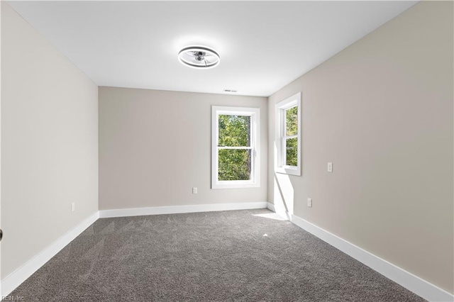 empty room featuring baseboards, visible vents, and carpet flooring