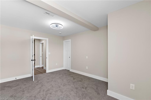 empty room featuring baseboards, visible vents, and dark colored carpet