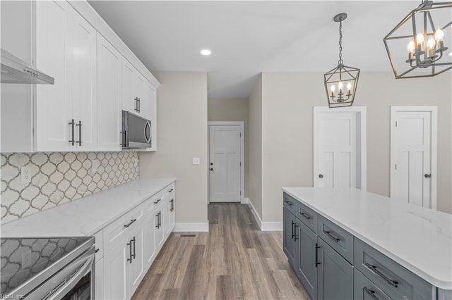 kitchen featuring backsplash, appliances with stainless steel finishes, white cabinets, pendant lighting, and gray cabinets