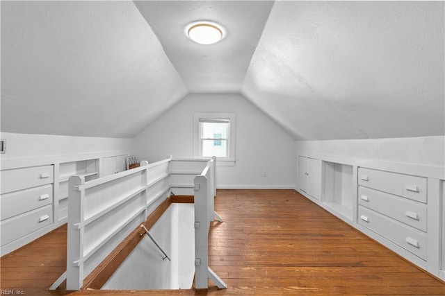 additional living space featuring lofted ceiling and wood-type flooring