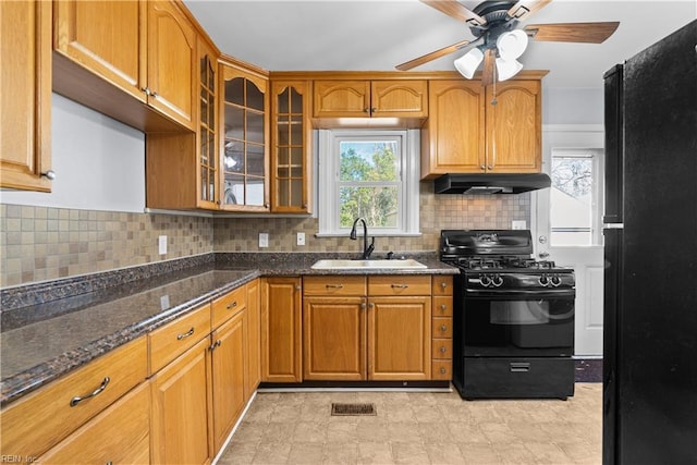 kitchen with sink, ceiling fan, black appliances, decorative backsplash, and dark stone counters