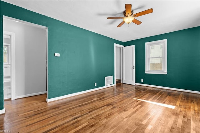 unfurnished room featuring wood-type flooring, plenty of natural light, and ceiling fan