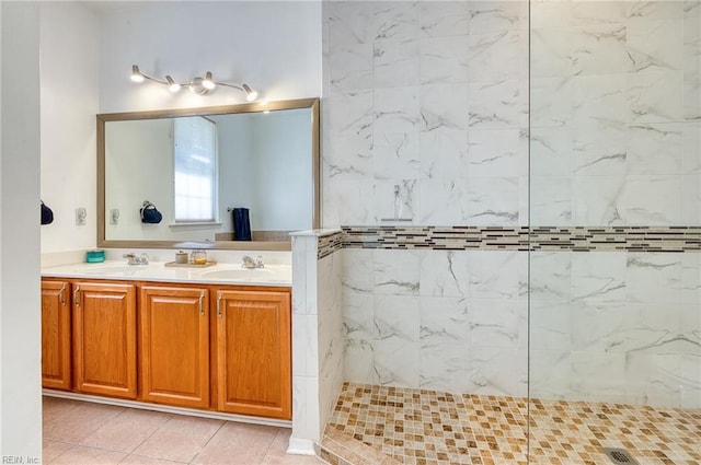 bathroom with tile patterned floors, tiled shower, and vanity