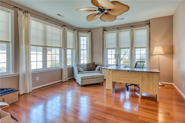 home office with light wood-type flooring and ceiling fan