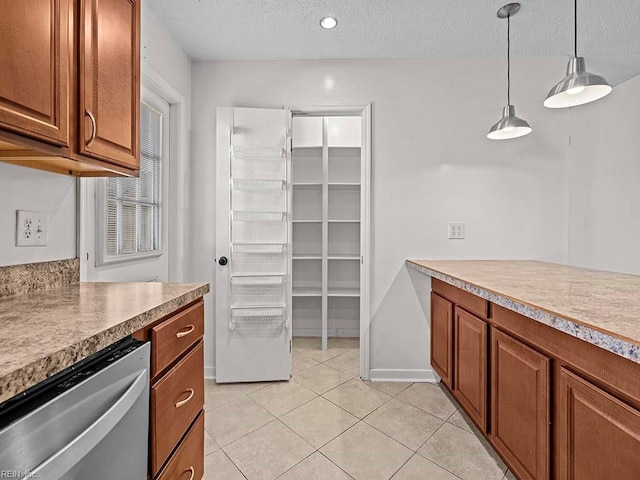 kitchen featuring light tile patterned flooring, pendant lighting, dishwasher, and a textured ceiling