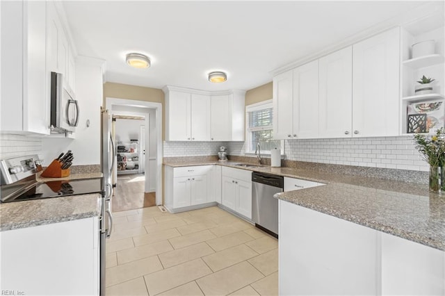 kitchen with white cabinets, open shelves, stainless steel appliances, and a sink