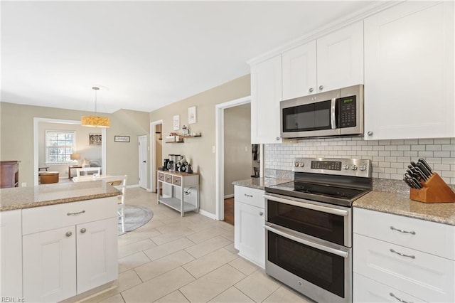 kitchen with white cabinets, decorative backsplash, light stone counters, appliances with stainless steel finishes, and hanging light fixtures