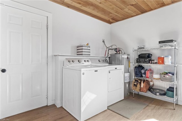 laundry room featuring washing machine and clothes dryer, light wood-style flooring, wood ceiling, electric water heater, and laundry area