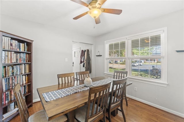 dining area featuring a ceiling fan, light wood-style flooring, and baseboards