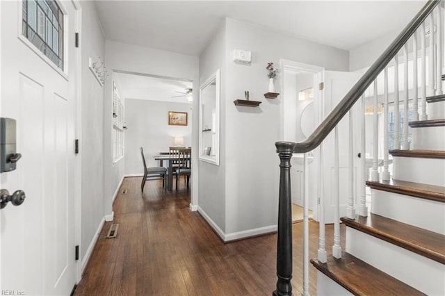 corridor featuring visible vents, stairway, hardwood / wood-style flooring, and baseboards