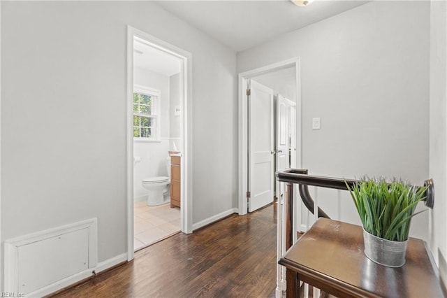 hallway with dark wood-style floors and baseboards