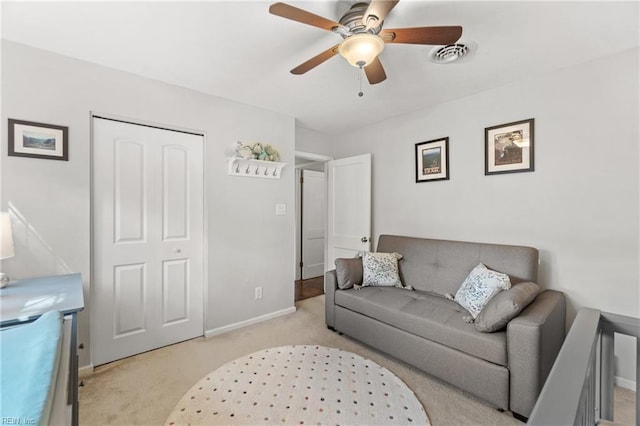 living room with light carpet, baseboards, visible vents, and ceiling fan