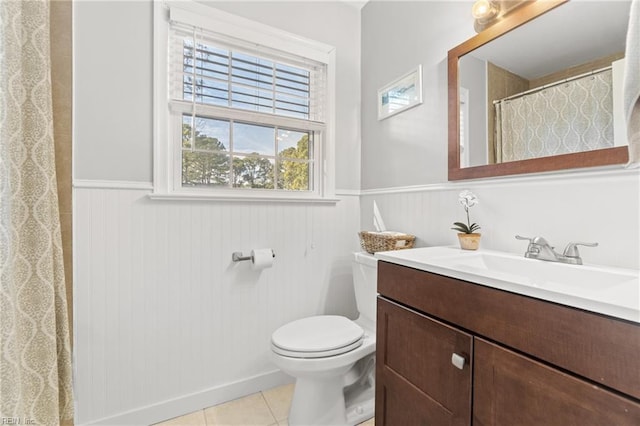 full bathroom featuring toilet, a wainscoted wall, tile patterned flooring, and vanity