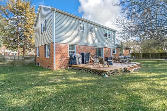 rear view of house with brick siding, a yard, crawl space, a fenced backyard, and a wooden deck