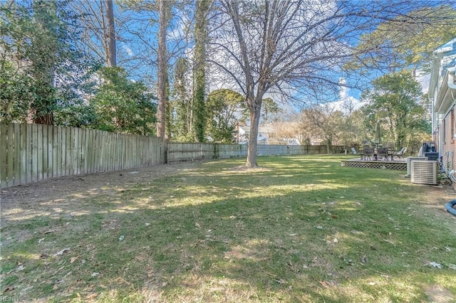 view of yard with a deck, a fenced backyard, and central air condition unit