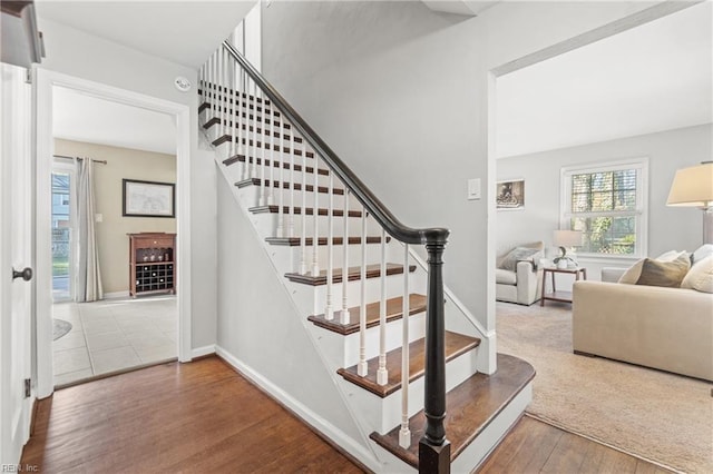 staircase featuring baseboards and wood finished floors