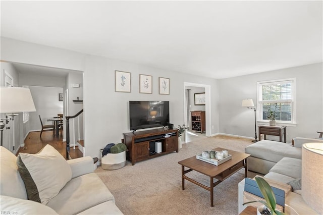 living room featuring stairway, carpet flooring, and baseboards