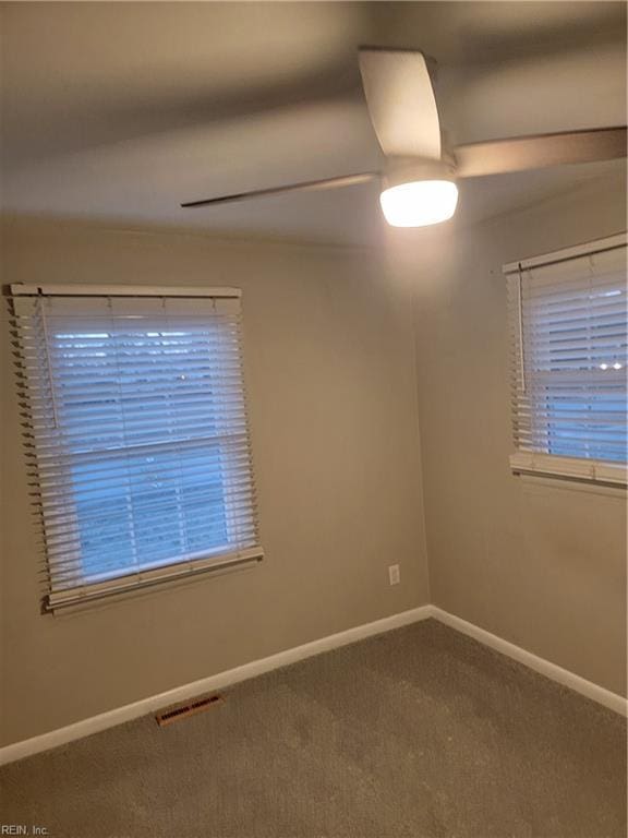 carpeted spare room with ceiling fan