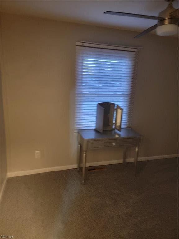 unfurnished office with ceiling fan and carpet