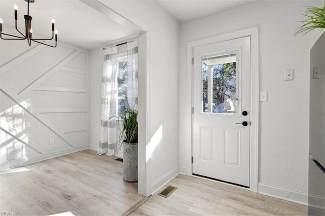 entryway featuring light hardwood / wood-style floors and a chandelier