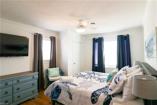 bedroom with a textured ceiling, ceiling fan, and dark hardwood / wood-style flooring