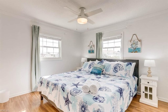 bedroom featuring light wood-type flooring, crown molding, and ceiling fan