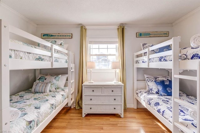 bedroom featuring light hardwood / wood-style floors, crown molding, and a textured ceiling