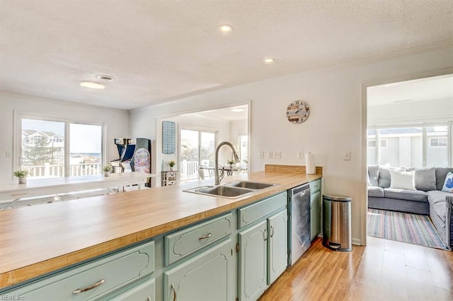 kitchen with sink, light hardwood / wood-style floors, a wealth of natural light, and dishwasher