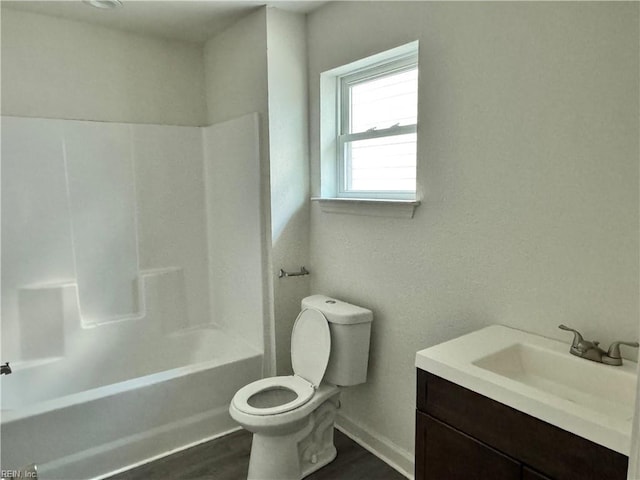 full bathroom featuring hardwood / wood-style flooring, vanity, shower / bathtub combination, and toilet