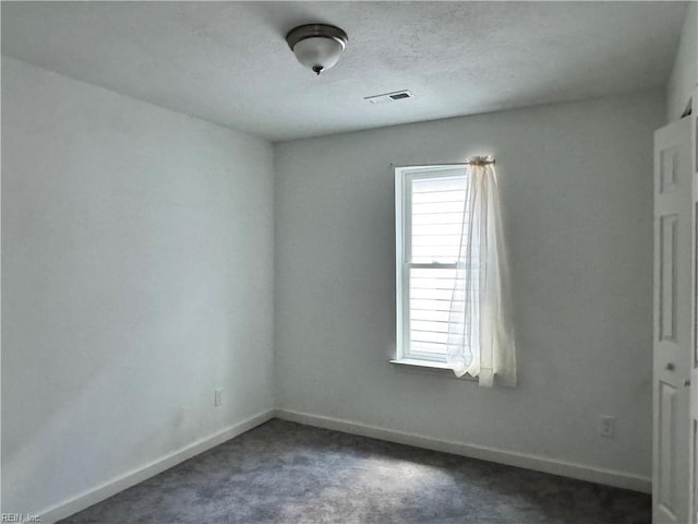 carpeted spare room with a textured ceiling