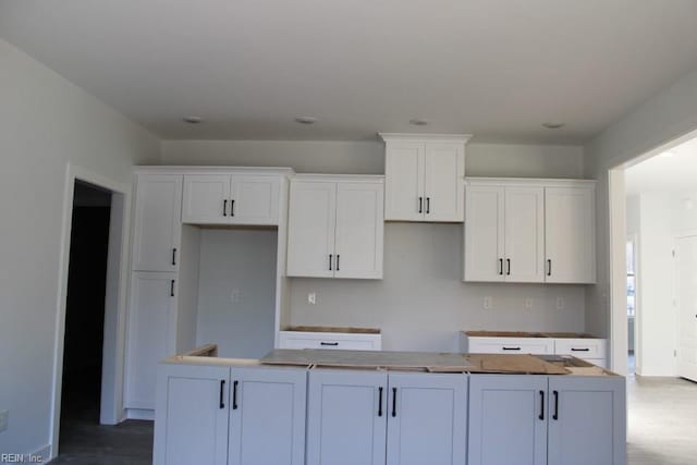kitchen with white cabinetry, a center island, and hardwood / wood-style floors