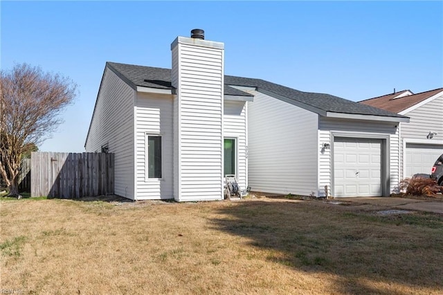 view of side of property featuring a garage and a lawn