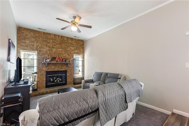 living room featuring a fireplace, crown molding, and ceiling fan