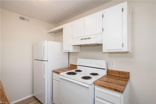 kitchen featuring white appliances, white cabinetry, and a textured ceiling