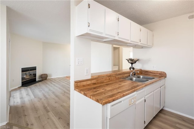 kitchen with sink, white cabinets, light hardwood / wood-style floors, and dishwasher