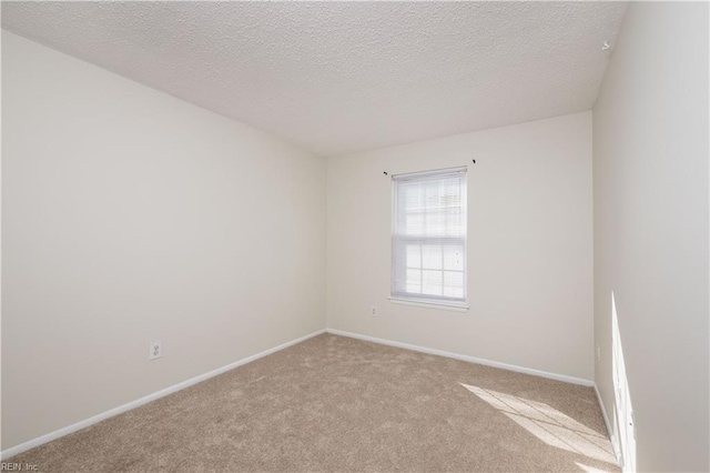 carpeted empty room featuring a textured ceiling