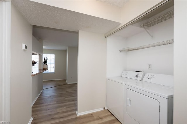 clothes washing area featuring light hardwood / wood-style floors and separate washer and dryer