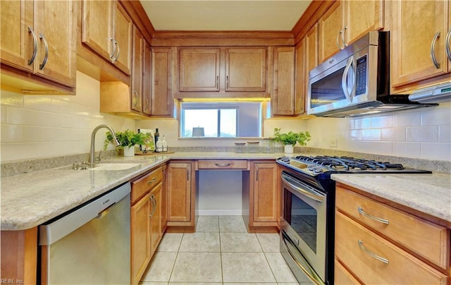 kitchen with light tile patterned floors, sink, stainless steel appliances, and light stone countertops